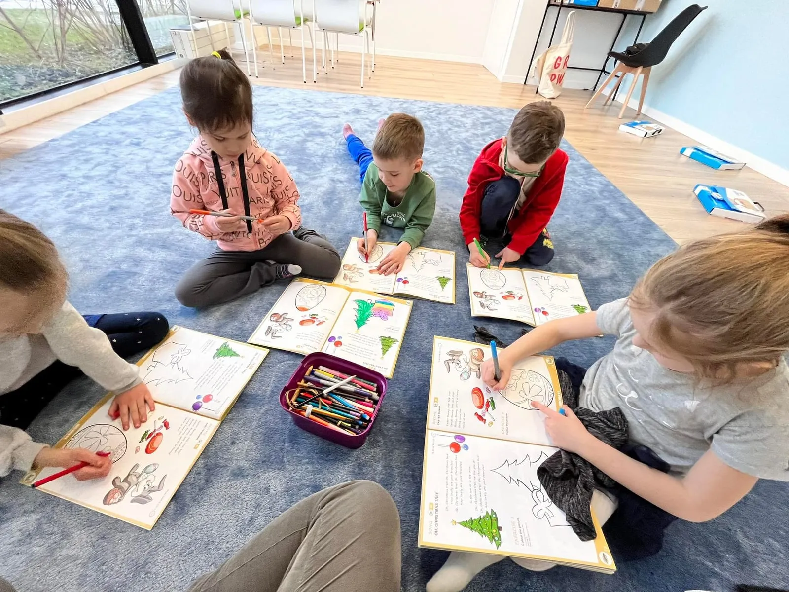 Children working at a table during an art activity in English